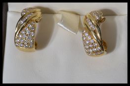A hallmarked pair of 18ct gold and diamond earrings. The earrings having 68 pave and channel set