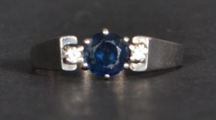An 18ct gold sapphire and diamond ring having a central sapphire flanked by two diamonds. Size S