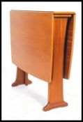 A retro 20th century G-Plan style teak drop leaf dining table having shaped supports, the end leaves