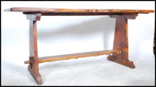 An early to mid 20th century large trunk wood refectory dining table. Raised on shaped supports
