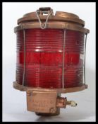 A vintage 20th century brass and wire caged mast / navigational lamp light  having red glass lining,