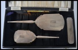 A silver hallmarked dressing table set complete in the original box comprising mirrors and brushes (