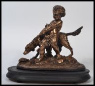After Auguste Joseph Peiffer. A 20th century bronze effected statuette of a child and dog raised