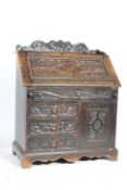 A Victorian oak Jacobean revival bureau. Raised on bracket feet with twin door cupboard. Above a