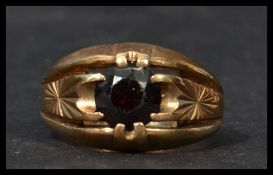 A hallmarked 9ct gold garnet stone ring having a central faceted stone with split and engraved