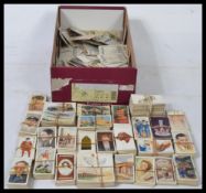 A shoe box of vintage cigarette cards , many hundreds of odd cards and part sets.