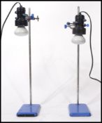 A matching pair of vintage 20th century inspection lights being mounted on medical test tube stands.