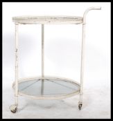 A vintage 1930's French conservatory trolley table of metal form having twin circular glass tiers