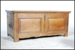 A 19th century French oak / chestnut coffer chest having a large hinged top over fielded panel