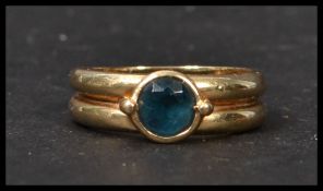 A 9ct gold hallmarked ring having a double band with central blue stone. Weighs 4 grams size P.