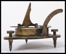 A vintage 20th century brass compass with engraved detail on three adjustable screw feet marked