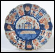 An Oriental Chinese Kangxi period (1690-1720) Imari pattern scalloped edge plate hand painted with