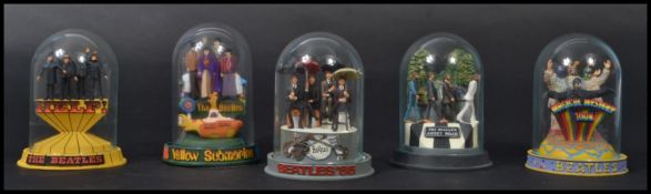 A set of 5 Franklin Mint figurines of The Beatles, each from a featured album artwork. Each figure