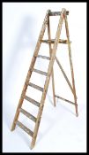 A retro 20th century wooden Industrial ladder having a-frame construction with a series of steps -