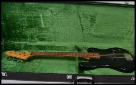 A vintage cased 20th century black bodied bass guitar by encore with a green velvet lined flight