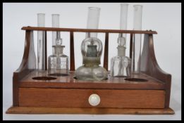 A vintage 20th century scientific test tube rack with various vials and bottles having an ivorine