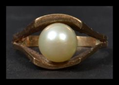 A 9ct gold pearl ring being hallmarked. The central large pearl on suspension setting. Total