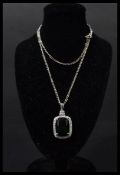 A silver CZ and faux emerald necklace pendant set to a silver chain in presentation box.