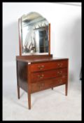 An Edwardian mahogany dressing table chest of drawers having a central swing mirror over three