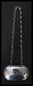 A 19th century Georgian silver hallmarked decanter label and chain engraved with whisky motif.
