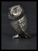 A sterling silver miniature figurine of an owl having inset glass eyes. Weighs 20.3 grams.