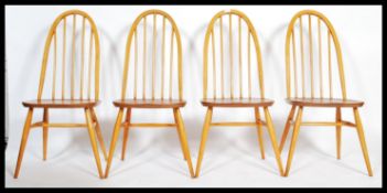 A set of four mid 20th century Ercol Windsor Quaker hoop-back dining chairs in light elm and