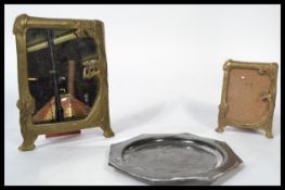 A graduating pair of Art Nouveau gilt brass easel back picture frames modelled with floral sprays