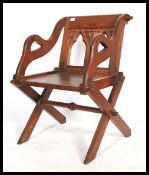 A 20th century solid oak  Glastonbury throne chair, ecclesiastical carvings to the back supported by