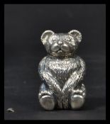 A sterling silver bear pincushion having blue baize cushion in the manner of Adie and Lovekin.