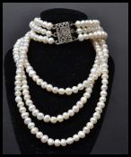A three row freshwater pearl strand pearl necklace with CZ clasp.