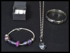 A group of sterling silver jewellery to include charm bracelet with various coloured charms by the