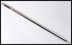 A vintage early 20th century walking stick cane having a tapering wooden shaft with brass collar and