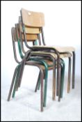A stack of four vintage mid 20th century industrial tubular grey metal framed stacking chairs with