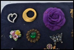 A collection of costume jewellery brooches mounted on a board together with silver / silver metal
