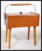 A good vintage 20th century teak wood retro sewing box being raised on atomic style legs with