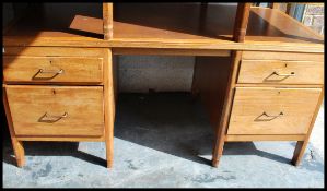 A mid century large Air Ministry twin pedestal oak desk. Raised on squared legs with a series of