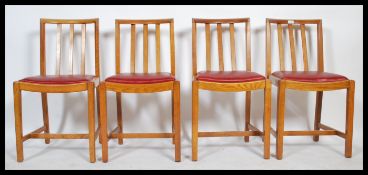 A set of four 1930's Art Deco dinning chairs in oak, drop in seat pads with rail back supports.