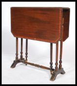 An Edwardian mahogany inlaid Sutherland table having an inlaid top being raised on ring turned