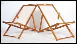 A pair of vintage 20th century style folding canvas and wooden framed deck / sun lounger beach