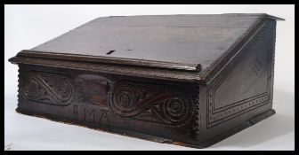 A 17th century Jacobean oak and elm clerks desk / bible box, hinged sloping lift up top with