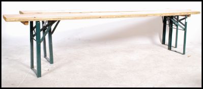 A pair of 20th century wooden and metal folding event benches. The planked tops of rectangular