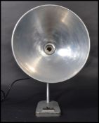 A fantastic mid 20th century desk lamp raised on a cast metal base with a sweeping polished steel