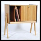 A mid century teak wood record cabinet in the manner of Robin Day. The a-frame legs with sliding