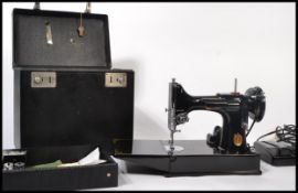 A vintage 20th century Singer Featherlite sewing machine being complete in the original carry case