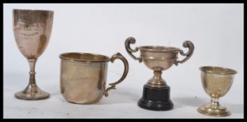 A group of silver hallmarked items to include a Christening cup and egg cup set a trophy on stand