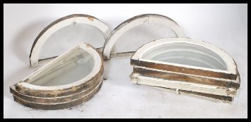 A set of 10 early 20th century painted wooden framed vintage arched - half moon glass windows panes.