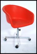 A 1970's vintage orange polypropylene formed bucket / desk chair raised on a metal gas pump column