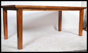 A 20th century hard wood refectory dining table raised on block supports together with a matching