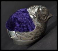 A sterling silver pin cushion in the form of a chick with purple cushion to back , in the manner