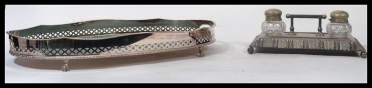 A Victorian silver plated twin desk top ink well desk tidy. The silver plated base on shaped feet